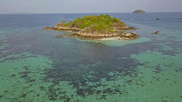 鸟瞰图的热带海滩，长尾船，皮划艇和岩石海岸与水晶清澈的绿松石水Koh Kla, Koh Lipe, Satun，泰国视频素材