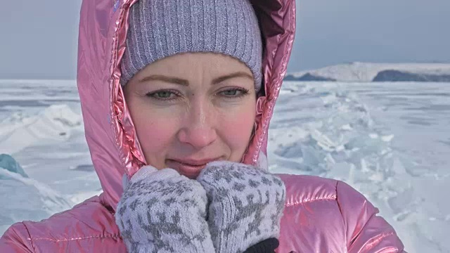 一个女孩走在贝加尔湖破裂的冰面上。一名女旅行者探索并看着一块浮冰。这是自然界中最神奇最纯净的地方。冰环绕着旅行者所有的旅程。视频素材