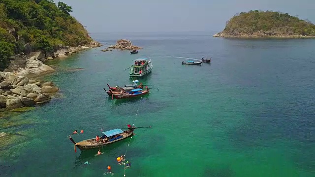 鸟瞰图的热带海滩，长尾船，皮划艇和岩石海岸与水晶清澈的绿松石的水Koh Lipe，萨顿，泰国视频素材