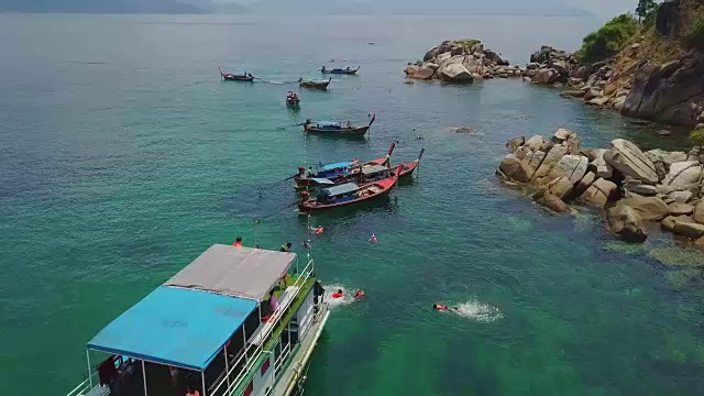 鸟瞰图的热带海滩，长尾船，皮划艇和岩石海岸与水晶清澈的绿松石的水Koh Lipe，萨顿，泰国视频素材