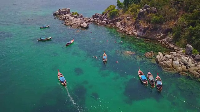 鸟瞰图的热带海滩，长尾船，皮划艇和岩石海岸与水晶清澈的绿松石的水Koh Lipe，萨顿，泰国视频素材