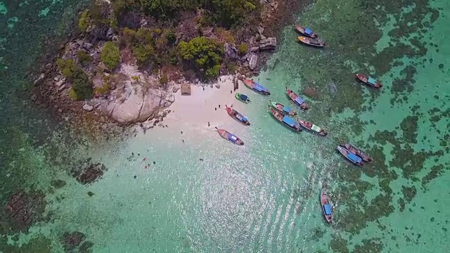 鸟瞰图的热带海滩，长尾船，皮划艇和岩石海岸与水晶清澈的绿松石水Koh岩，Koh Lipe, Satun，泰国视频素材