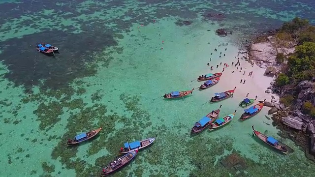 鸟瞰图的热带海滩，长尾船，皮划艇和岩石海岸与水晶清澈的绿松石水Koh岩，Koh Lipe, Satun，泰国视频素材