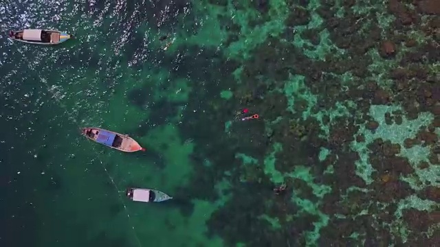 鸟瞰浮潜，长尾船和岩石海岸与水晶清澈的绿松石水Koh Kla, Koh Lipe, Satun，泰国视频素材