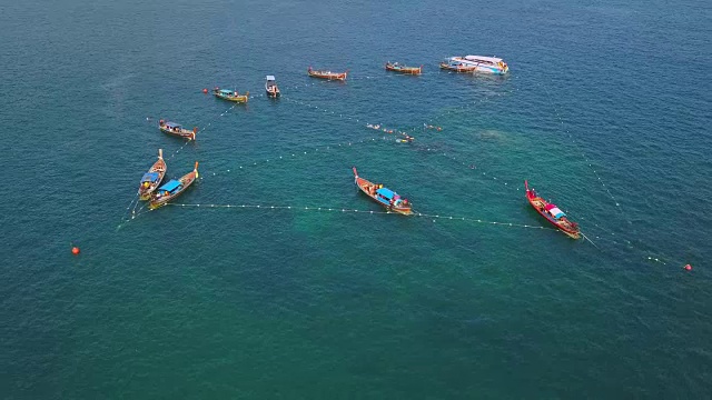 鸟瞰图的热带海滩，长尾船，皮艇和岩石海岸与水晶清澈的绿松石水加邦，利比，沙顿，泰国视频素材