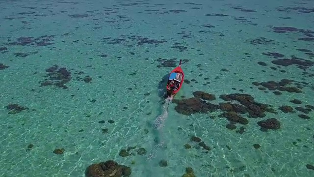 鸟瞰图跟踪亚洲妇女在比基尼，长尾船和岩石海岸与水晶清澈的绿松石水Koh Lipe，萨顿，泰国视频素材