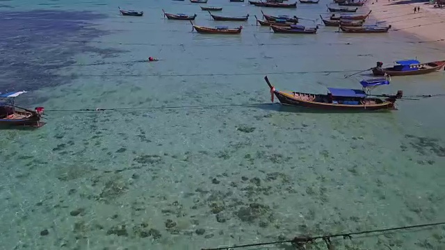 鸟瞰图的热带海滩，长尾船，皮划艇和岩石海岸与水晶清澈的绿松石水Koh Kla, Koh Lipe, Satun，泰国视频素材