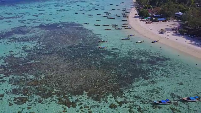 鸟瞰图的热带海滩，长尾船，皮划艇和岩石海岸与水晶清澈的绿松石水Koh Kla, Koh Lipe, Satun，泰国视频素材