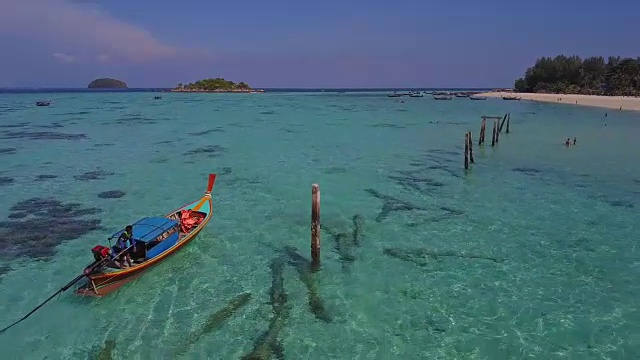 鸟瞰图的热带海滩，长尾船，皮划艇和岩石海岸与水晶清澈的绿松石水Koh Kla, Koh Lipe, Satun，泰国视频素材