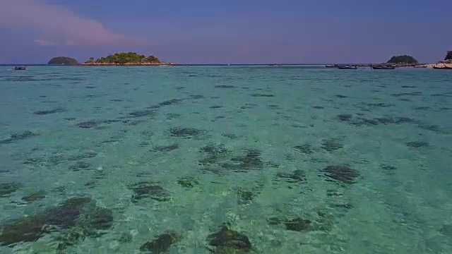 鸟瞰图的热带海滩，长尾船，皮划艇和岩石海岸与水晶清澈的绿松石水Koh Kla, Koh Lipe, Satun，泰国视频素材