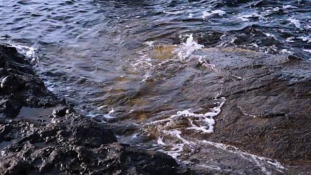 海水溅在岩石上。视频素材