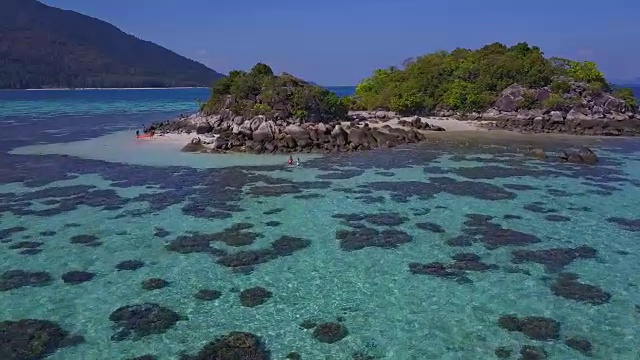 鸟瞰热带海滩，长尾船，皮划艇和岩石海岸与水晶清澈的绿松石水Koh Kla, Koh Lipe, Satun，泰国视频素材