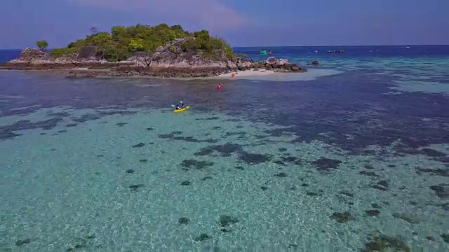 鸟瞰热带海滩，长尾船，皮划艇和岩石海岸与水晶清澈的绿松石水Koh Kla, Koh Lipe, Satun，泰国视频素材