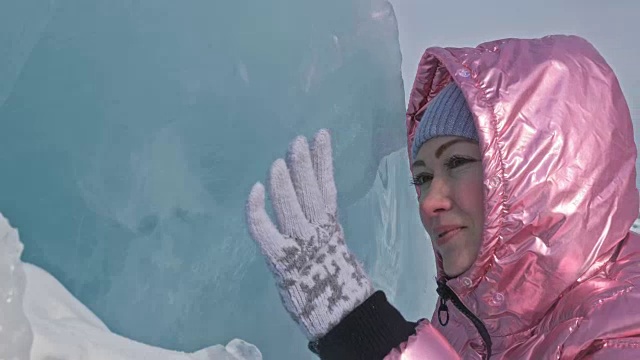 一个女孩走在贝加尔湖破裂的冰面上。一名女旅行者探索并看着一块浮冰。这是自然界中最神奇最纯净的地方。冰环绕着旅行者所有的旅程。视频素材