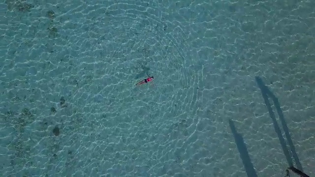 鸟瞰图，一个迷人的女人漂浮在水晶清澈的大海，泰国，萨顿视频素材