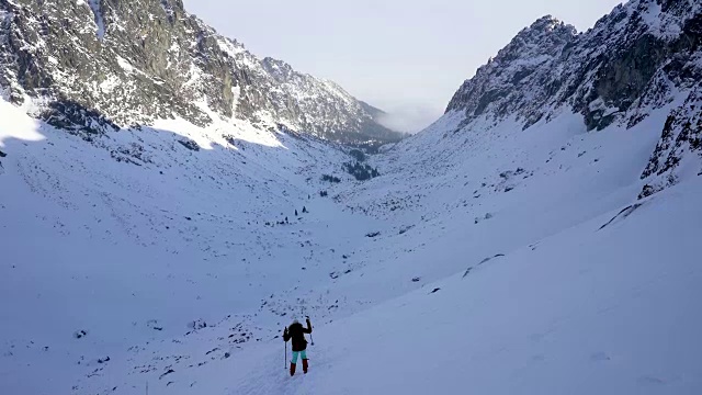 冬天在冰雪覆盖的岩石山脉徒步旅行视频素材