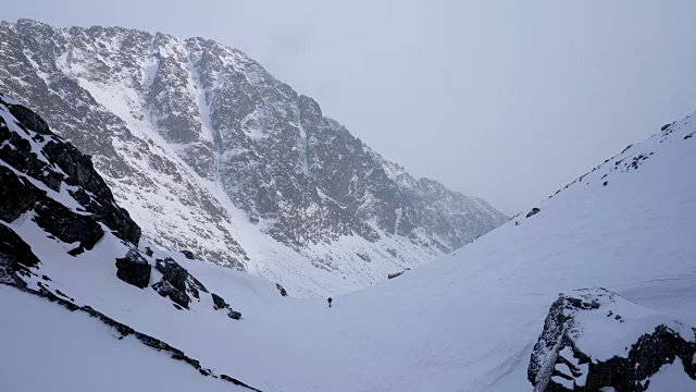 冬天在冰雪覆盖的岩石山脉徒步旅行视频素材