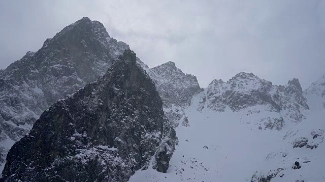 冬天在冰雪覆盖的岩石山脉徒步旅行视频素材