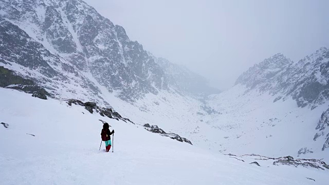 冬天在冰雪覆盖的岩石山脉徒步旅行视频素材