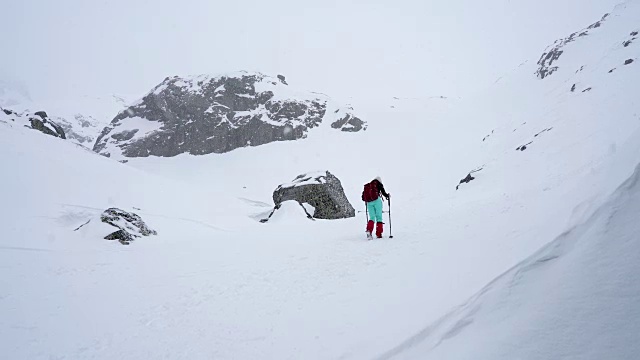 冬天在冰雪覆盖的岩石山脉徒步旅行视频素材