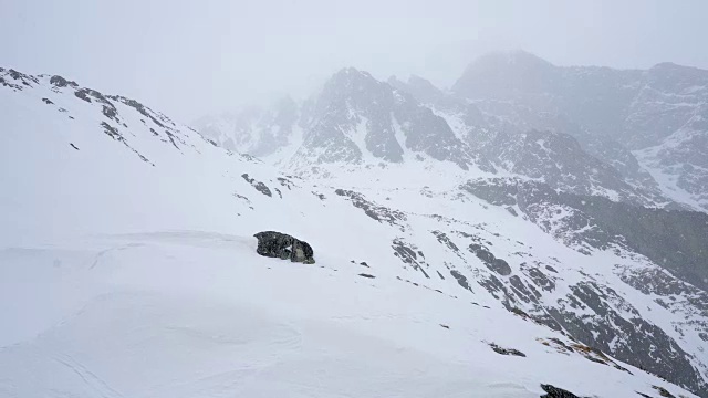 冬天在冰雪覆盖的岩石山脉徒步旅行视频素材