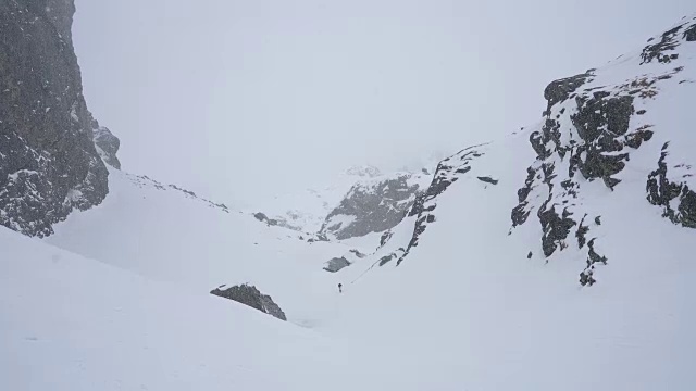 冬天在冰雪覆盖的岩石山脉徒步旅行视频素材