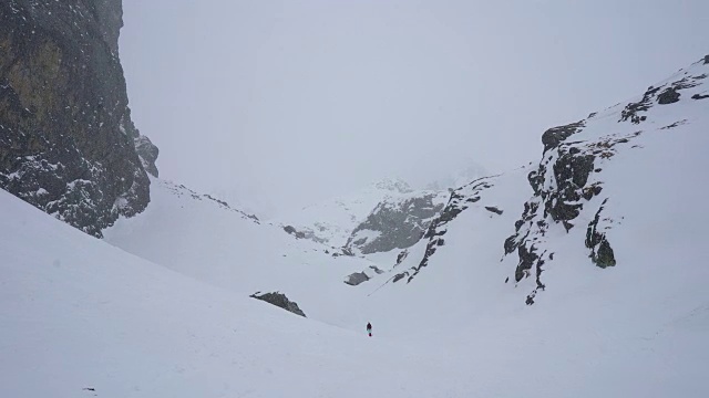 冬天在冰雪覆盖的岩石山脉徒步旅行视频素材