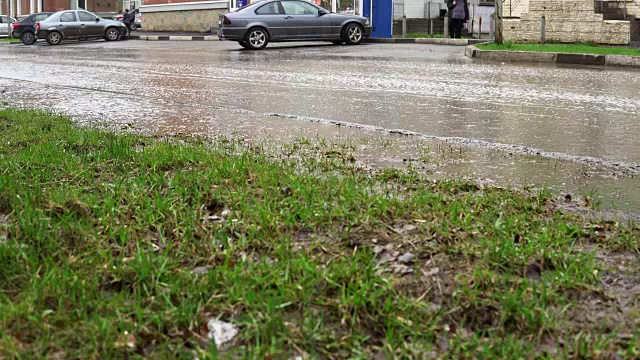 雨中，汽车在满是脏水的道路上行驶。视频素材