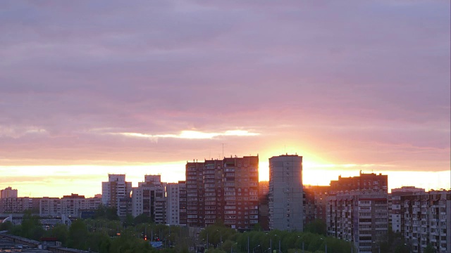 美丽的日落在城市多层建筑的背景时间流逝视频素材