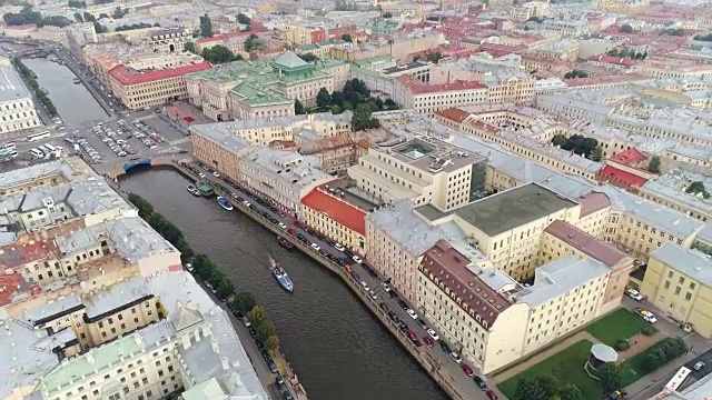 无人机在城市建筑和河上漂浮的船舶上的全景视频素材