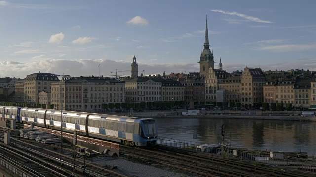 从Slussen，斯德哥尔摩，瑞典，斯堪的纳维亚，欧洲的铁路线和火车与格拉斯坦天际线可见视频素材