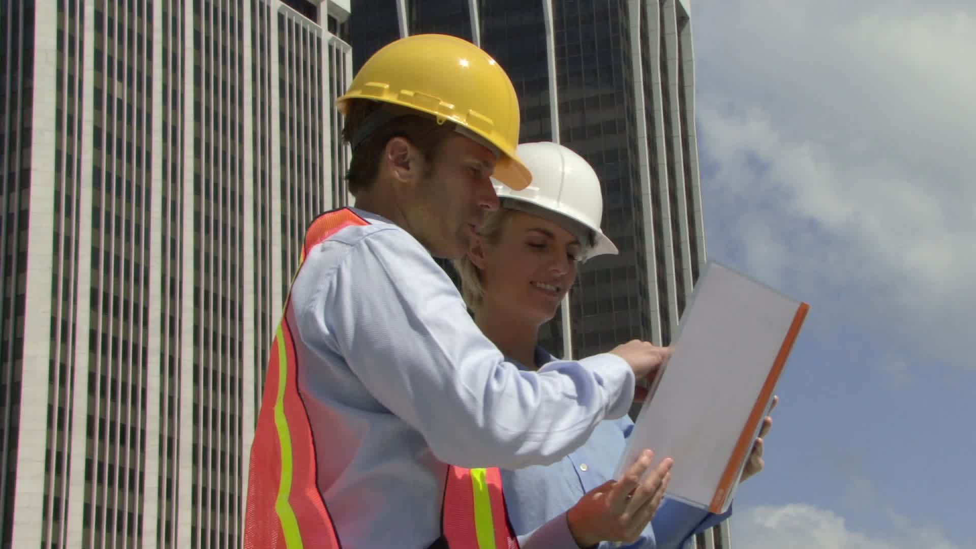 美国佛罗里达州迈阿密，男女建筑师在建筑工地上看平面图视频素材