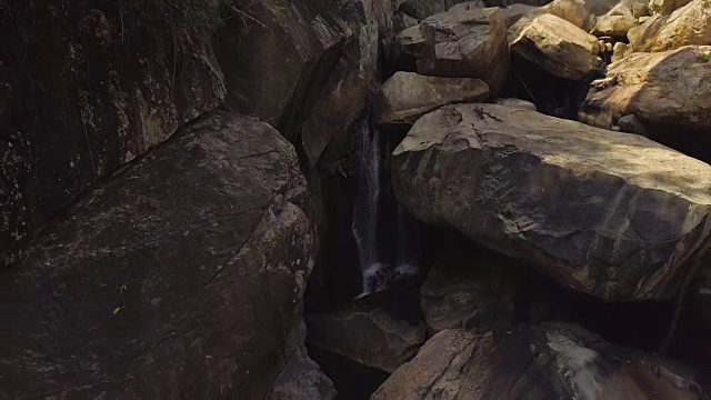 岩石瀑布在山区河流空中景观。流动的河水在山上瀑布在野生森林。无人机观看巨石和山川溪流视频素材