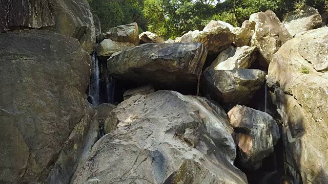 岩石瀑布在雨林鸟瞰图。山上的河流和大瀑布的石头在背景的绿色森林。野生自然景观视频素材