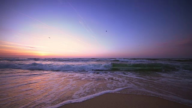 海滩和海浪上美丽的日出视频素材