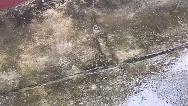 近距离的雨落在水泥地上。视频素材