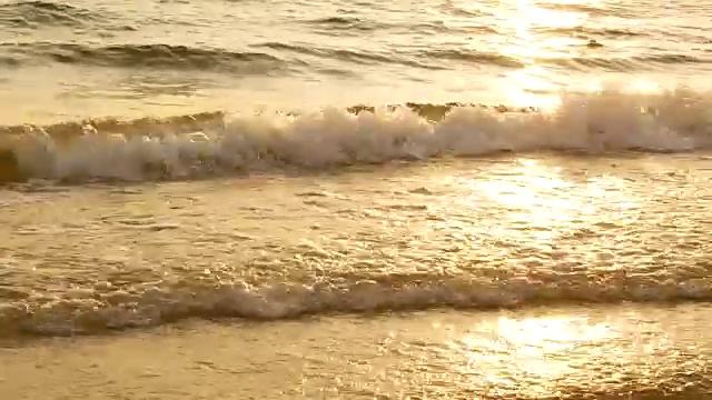 4K惊人的日落在热带海滩上。海边沙滩上的海浪在日落时分，阳光反射在水面上。美丽的黄昏自然海洋背景。视频素材