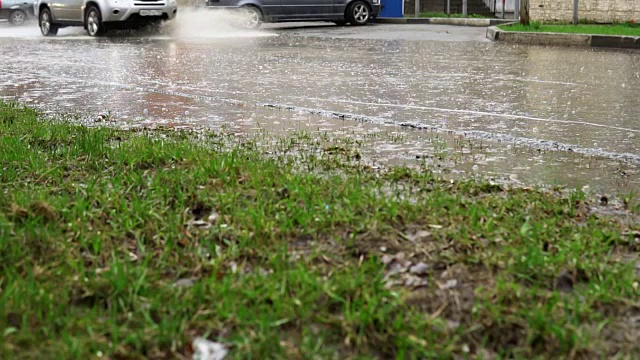 汽车在雨中行驶在被洪水淹没的道路上，慢镜头。视频素材