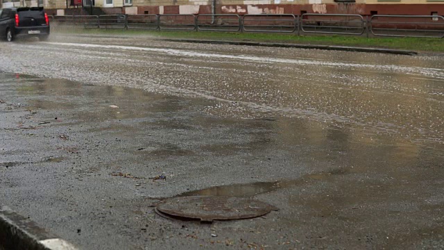 汽车在雨中行驶在被洪水淹没的道路上，慢镜头。视频素材