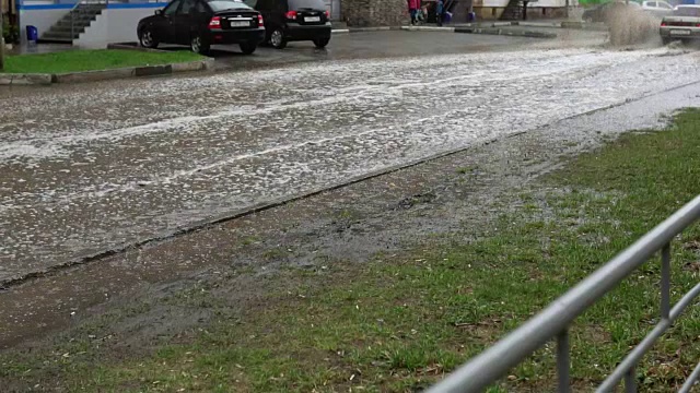 汽车在雨中行驶在被洪水淹没的道路上，慢镜头。视频素材