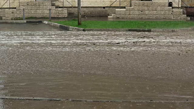 汽车在雨中行驶在被洪水淹没的道路上，慢镜头。视频素材