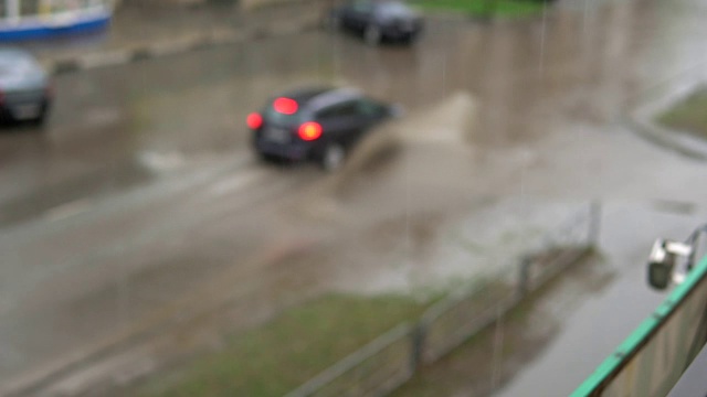 汽车在雨中行驶在被洪水淹没的道路上，慢镜头。视频素材