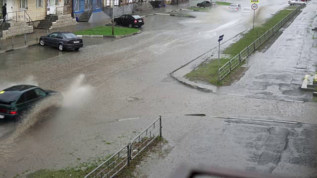 汽车在雨中行驶在被洪水淹没的道路上，慢镜头。视频素材