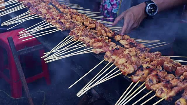 在pasar市场，小贩在木炭上烤烤鸡肉视频素材