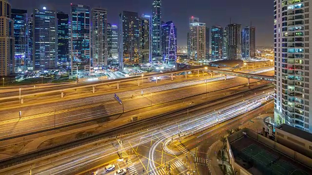 从空中俯瞰朱美拉湖的高楼大厦，日夜与谢赫扎耶德公路上的交通时间流逝视频素材