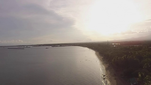 太阳落在空旷的沙滩和美丽的平静的大海在阴天，无人机空中视频素材