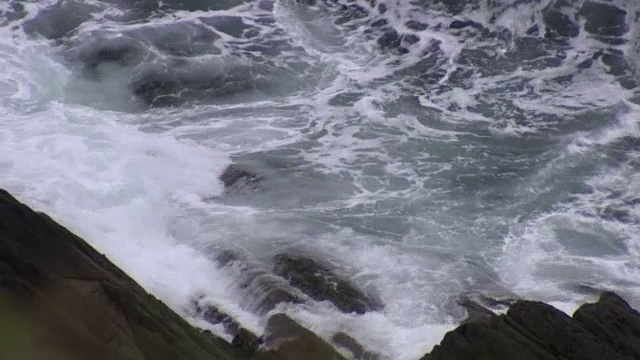 手持拍摄的海水遇见科克郡海岸的粗糙岩石，爱尔兰。视频素材