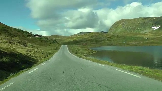 在挪威的公路上开车。挪威美丽的风景，湖泊和道路。挪威山区的一条路。视频素材