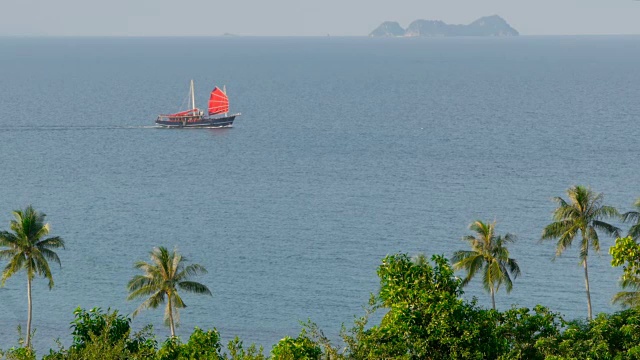 日落时分，一艘中国传统的红帆船在海上漂浮视频素材