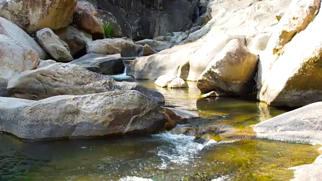 清澈的水在岩石河在山上近距离流动。湍急的水流从热带瀑布倾泻到山河。热带雨林中的野生自然视频素材